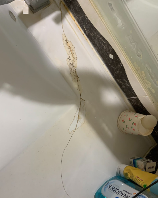 這是一個使用一段時間，經過撞擊，致使面盆瓷器出現裂痕的浴櫃